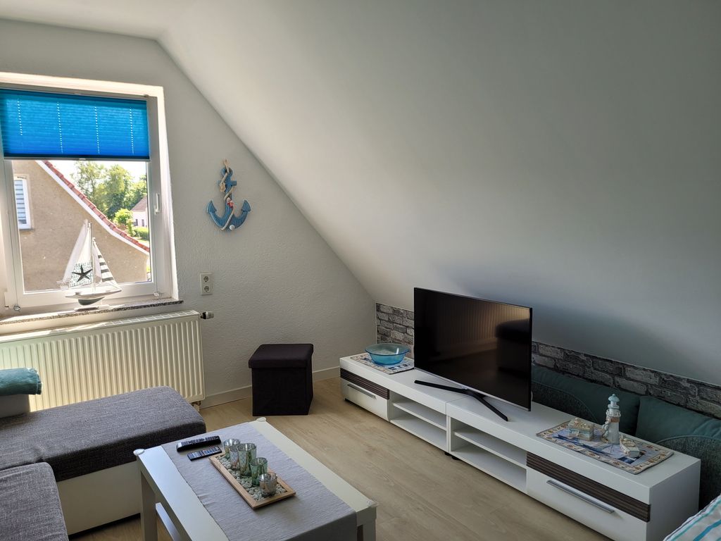 Wohnzimmer mit Couchecke, TV und Schlafcouch