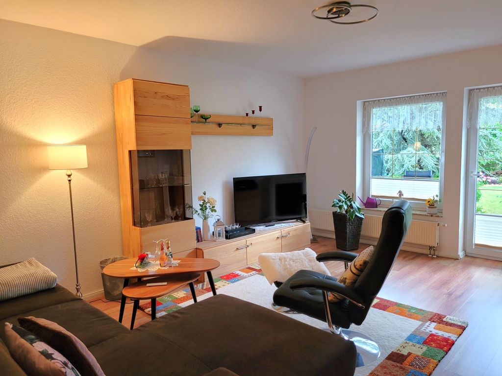 Wohnzimmer mit TV, gemütlicher (Schlaf-)Couch und Zugang zur Terrasse
