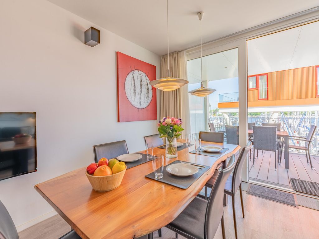 Heller Essbereich mit direktem Zugang zur Terrasse und Hafenblick.