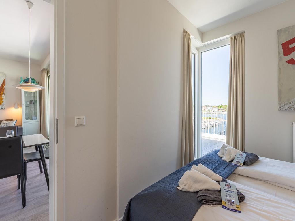 Gemütliches Schlafzimmer mit Balkon und Blick auf den Hafen.