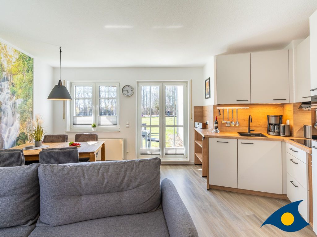 moderner Wohnbereich mit Küche und Zugang zum Balkon