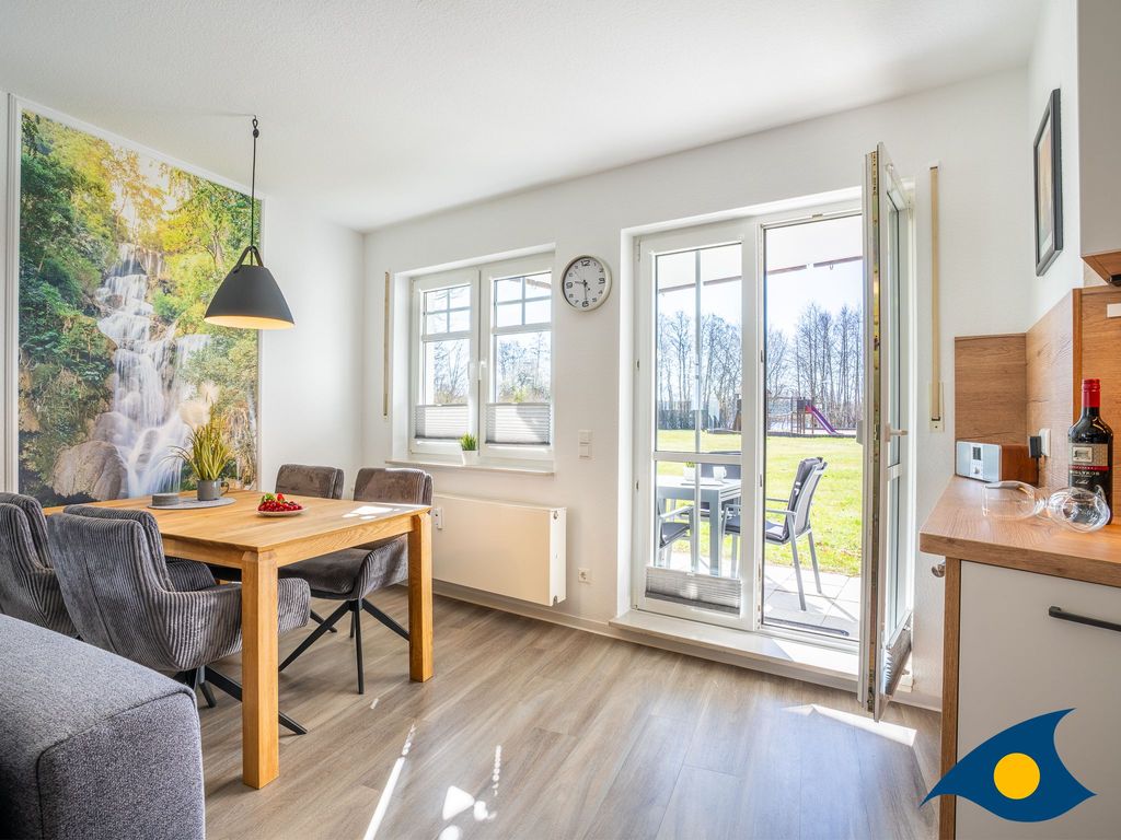 moderner Wohnbereich mit Küche und Zugang zum Balkon