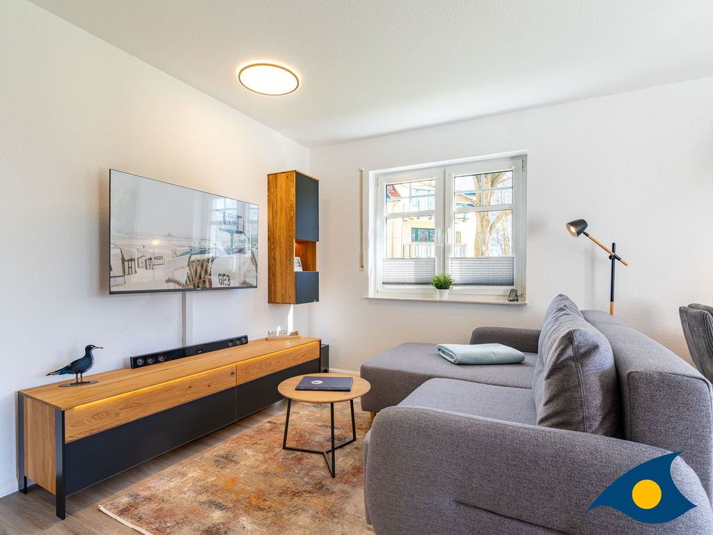 moderner Wohnbereich mit Küche und Zugang zum Balkon