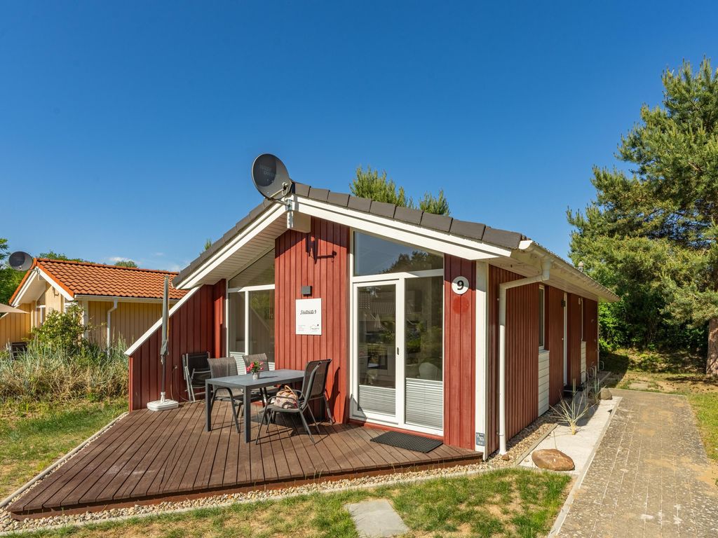Helle Terrasse mit Sitzbereich und Blick ins Grüne.
