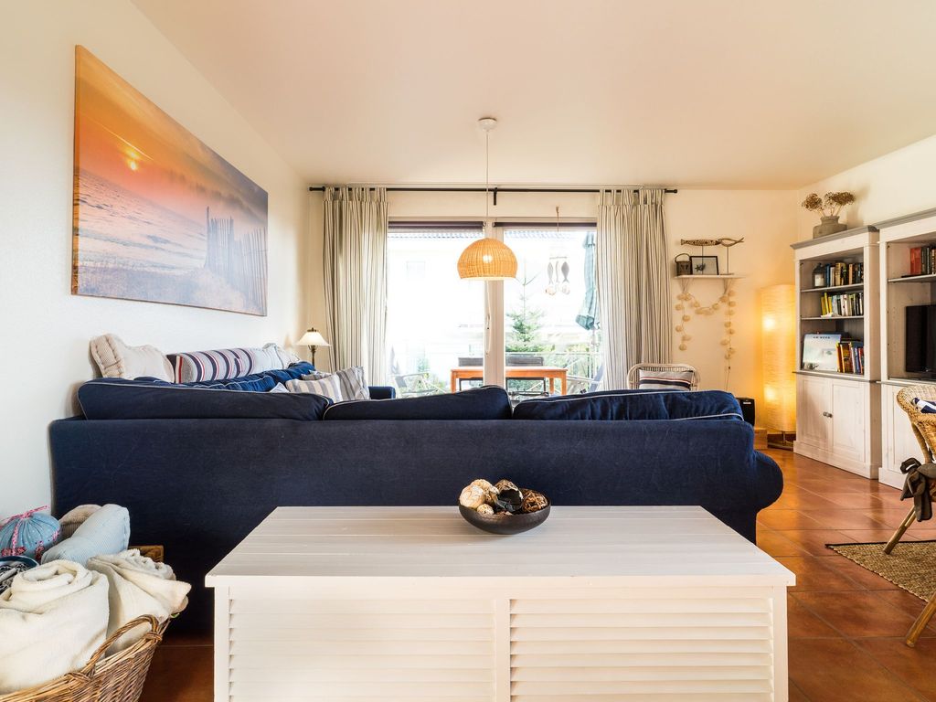 Wohnzimmer mit offener Küche und Zugang zum Balkon
