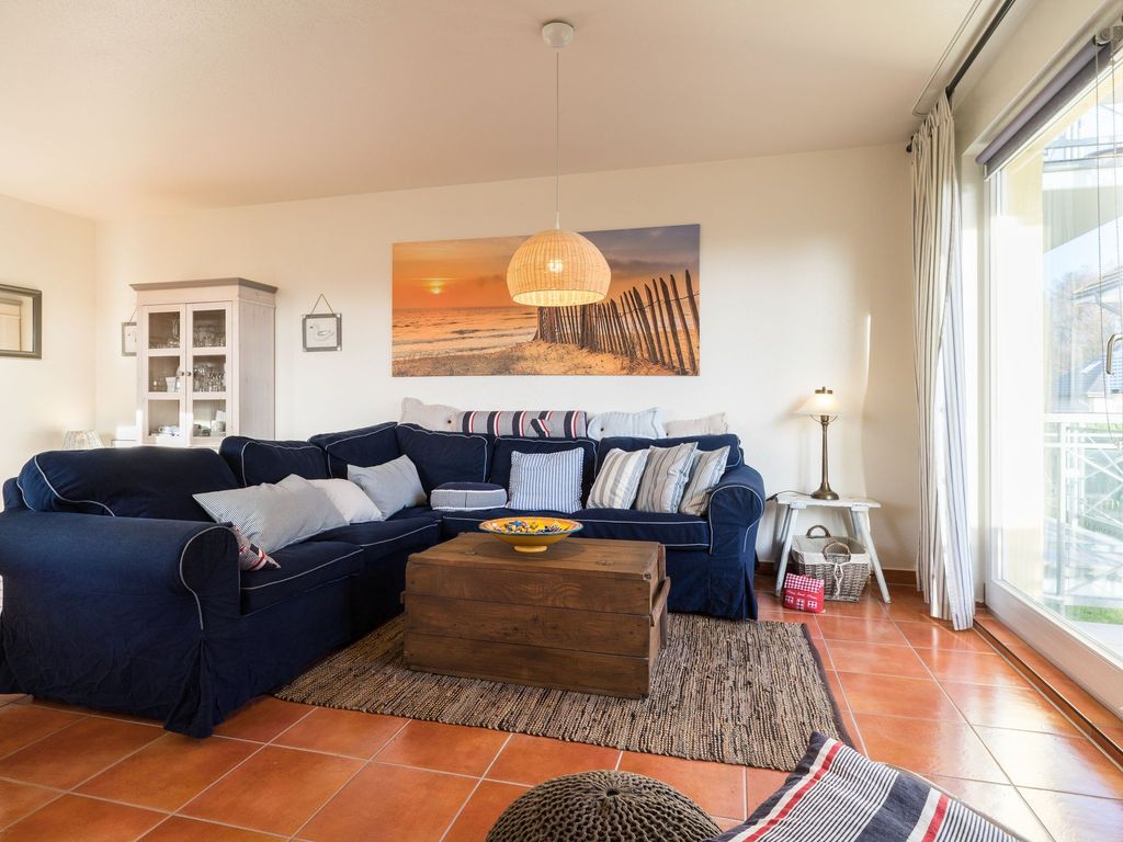 Wohnzimmer mit offener Küche und Zugang zum Balkon