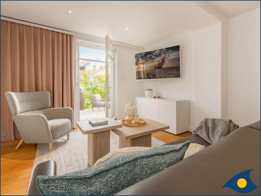 Wohnzimmer mit Schlafcouch und Zugang zur Terrasse