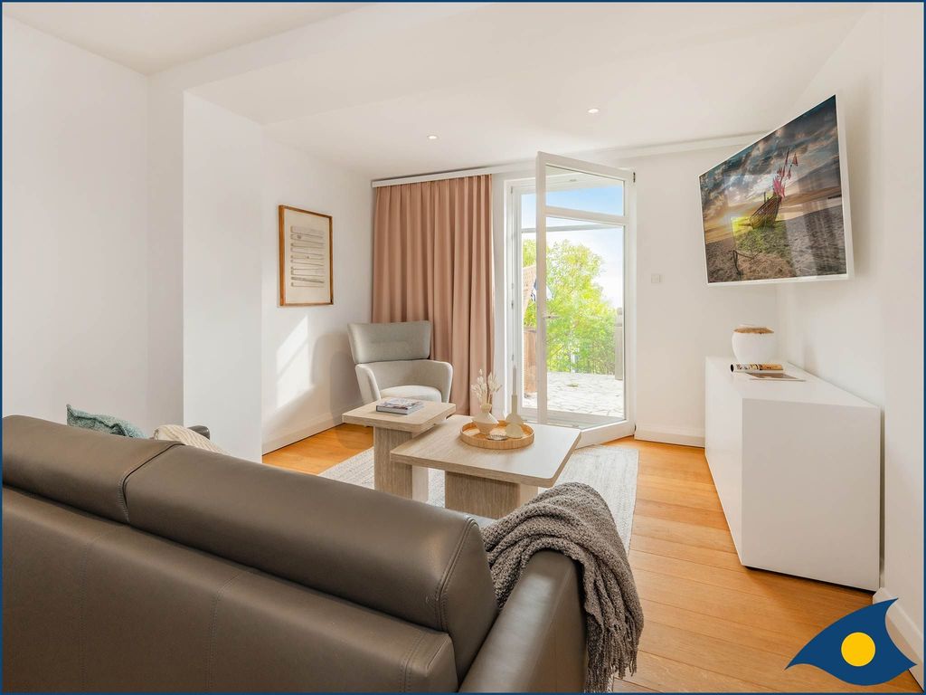 Wohnzimmer mit Schlafcouch und Zugang zur Terrasse