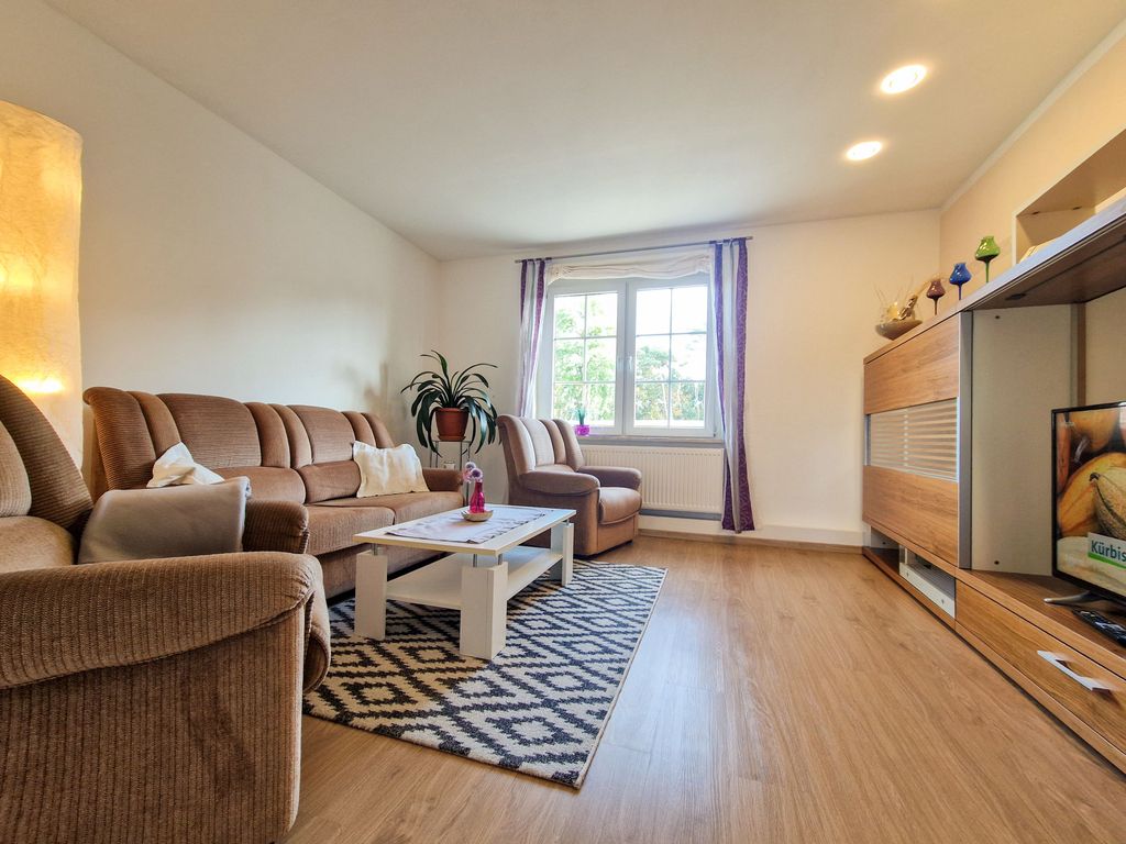 Wohnzimmer mit Sitzgelegenheiten und TV.