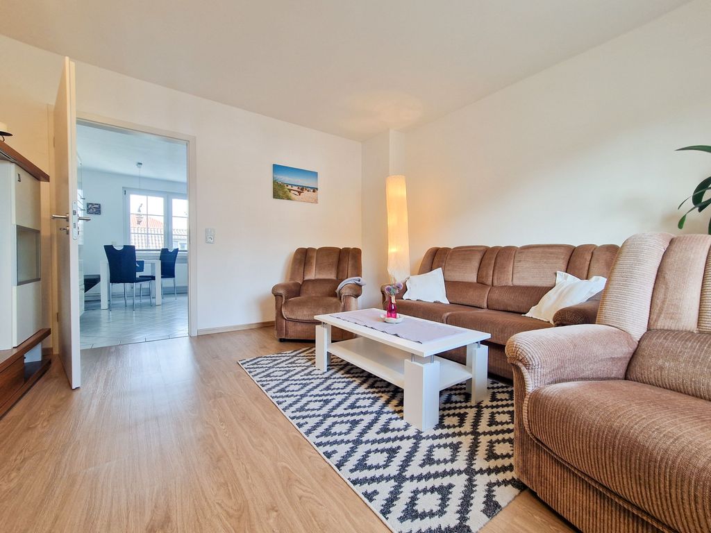 Wohnzimmer mit Sitzgelegenheiten und TV.