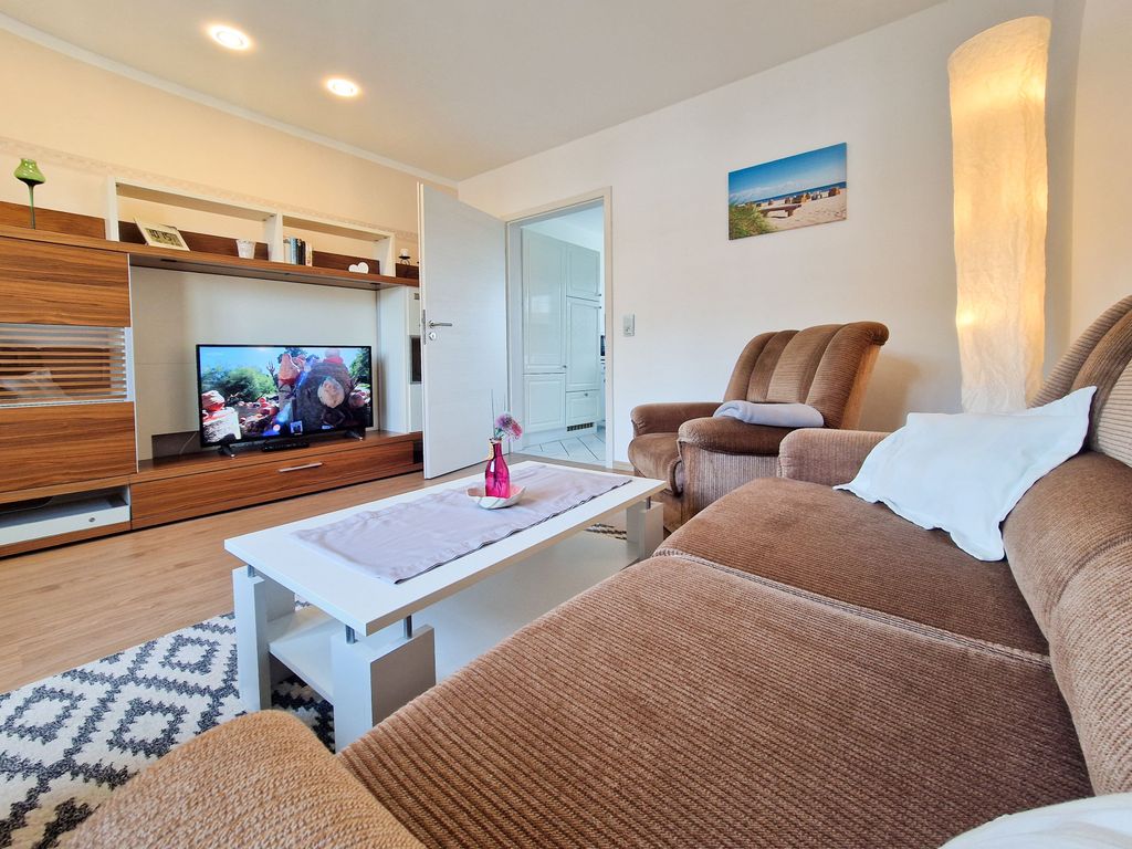 Wohnzimmer mit Sitzgelegenheiten und TV.