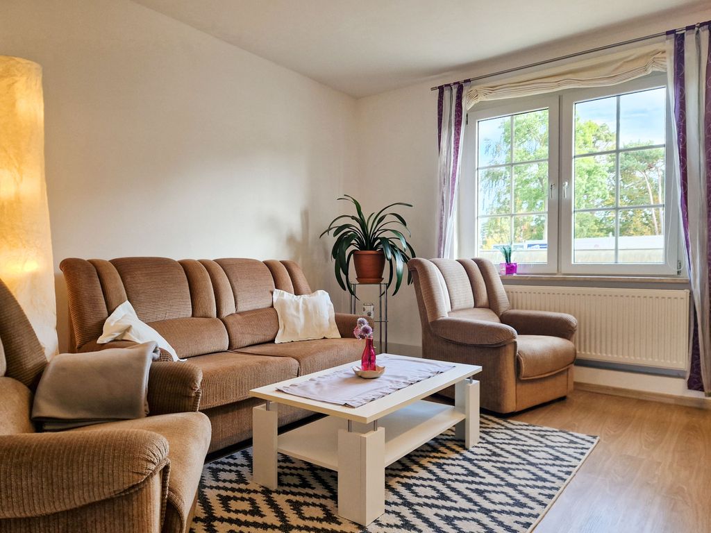 Wohnzimmer mit Sitzgelegenheiten und TV.