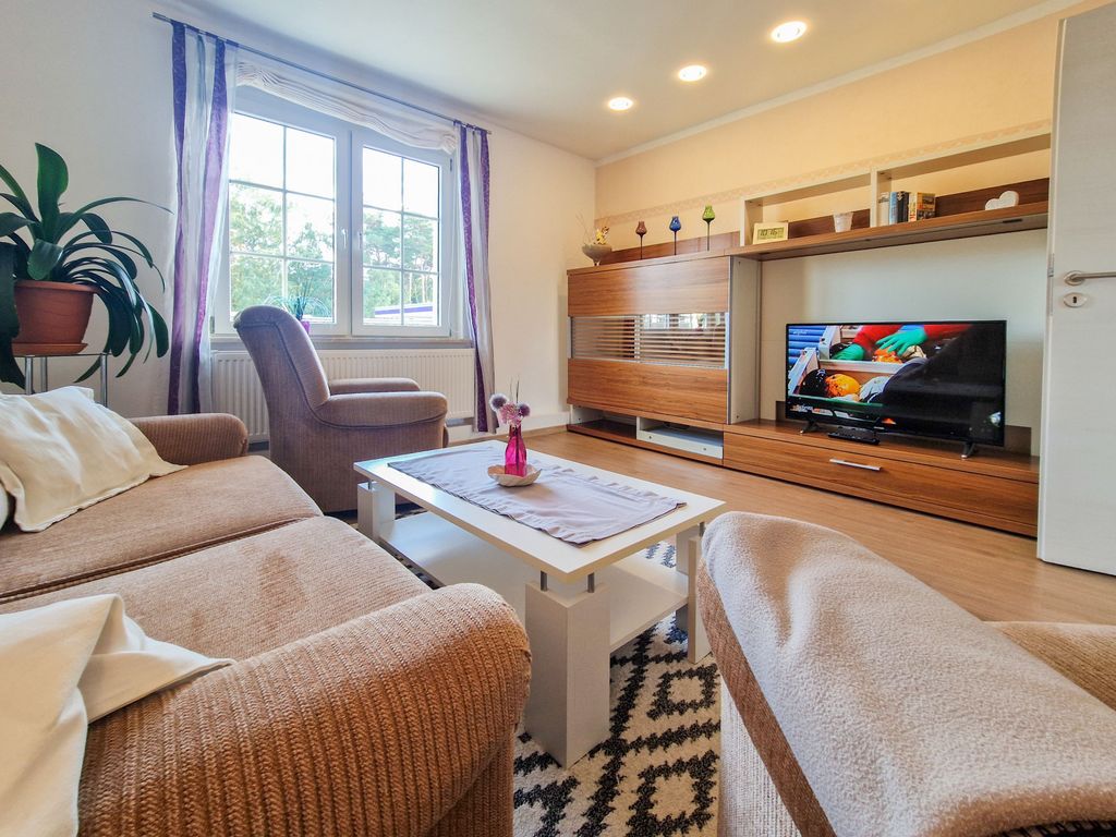 Wohnzimmer mit Sitzgelegenheiten und TV.