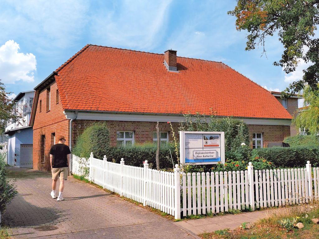 Ferienhaus mit Ziegeldach und weißem Zaun