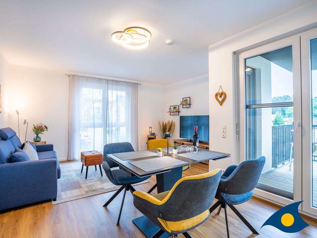 Wohnbereich mit offener Küche und Zugang zum Balkon