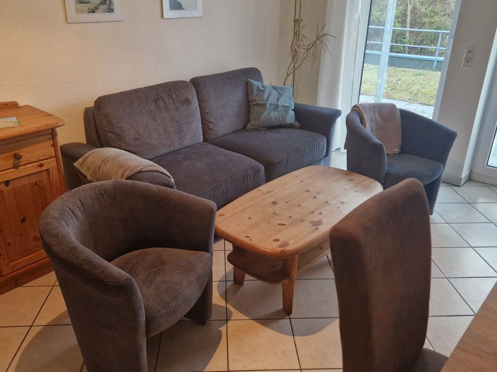 Neu gestaltetes Wohnzimmer mit aufbettbarer Schlafcouch und Blick auf die Terrasse.