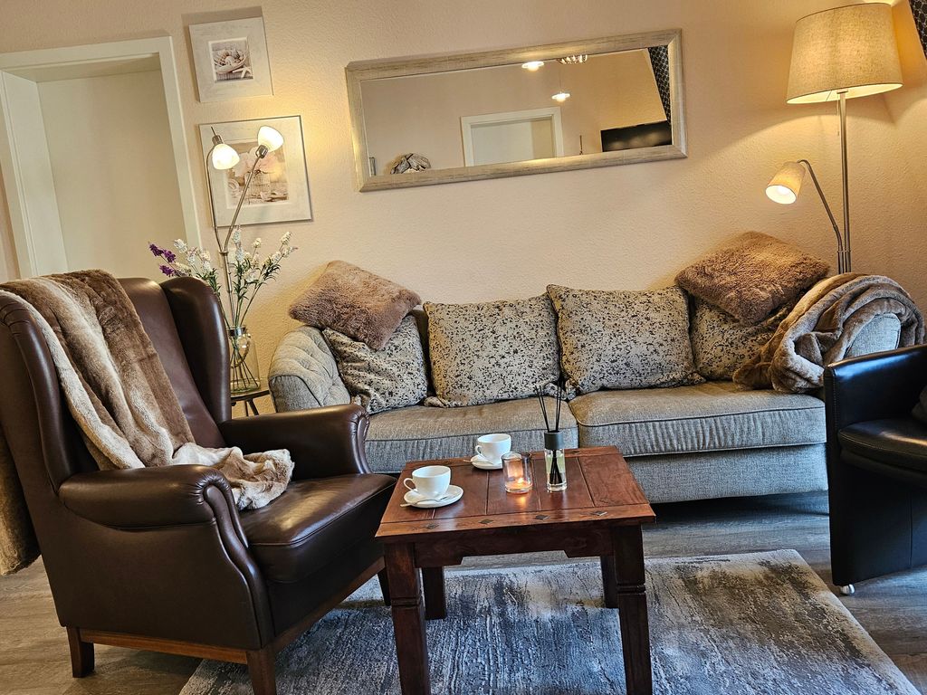 Super gemütlicher Wohnbereich mit kuscheligen Decken und Lederohrensessel