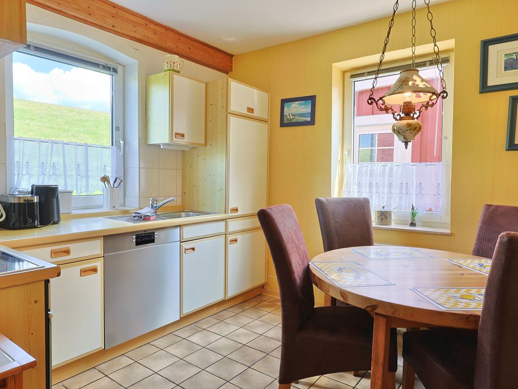 Seperate Küche mit Esstisch und Fenster zum Deich