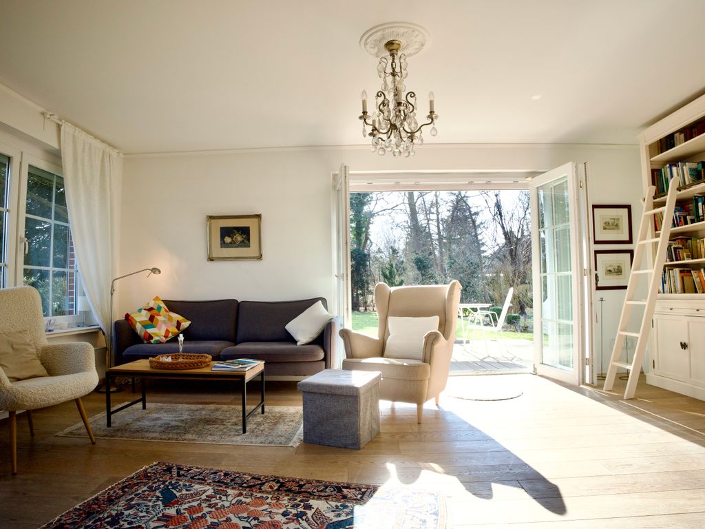 Stilvolles Wohnzimmer mit eigener Bibliothek und Gartenzugang