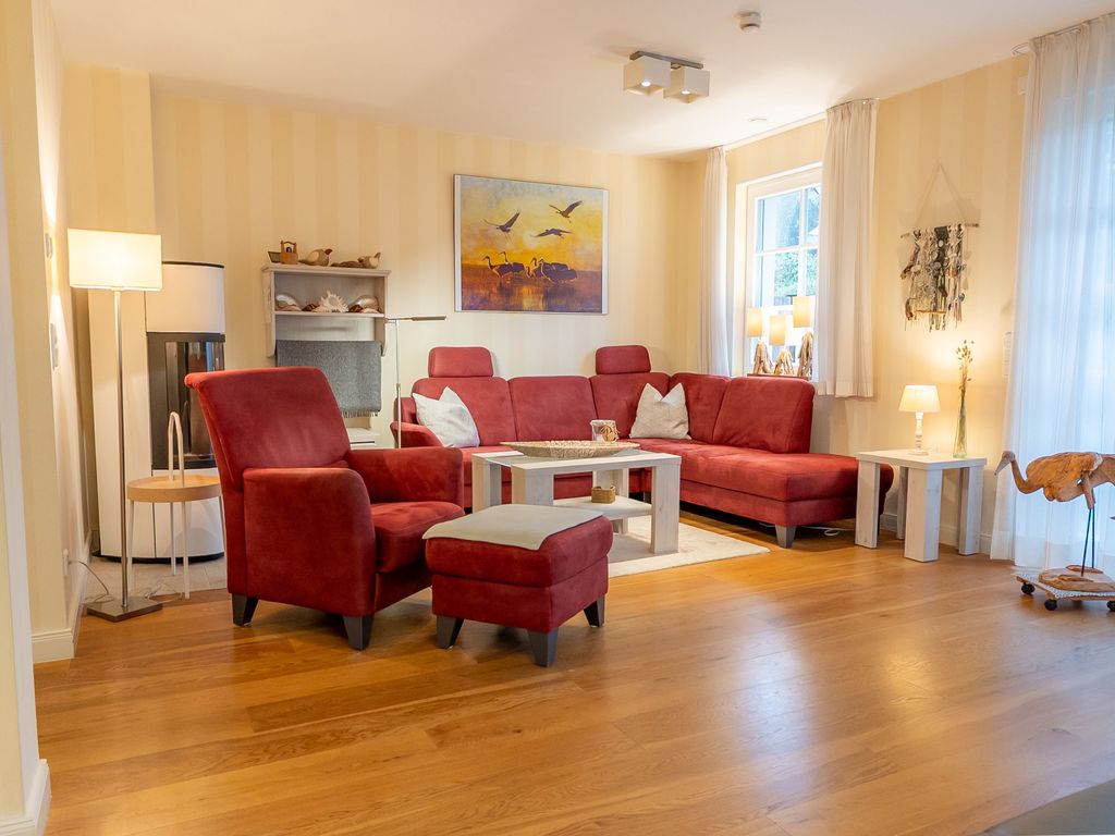Der gemütliche Wohnbereich mit bequemer Sofalandschaft und Sessel lädt zum Entspannen ein. Der moderne Pelletkamin sorgt an kühleren Tagen für wohlige Wärme und eine angenehme Atmosphäre.