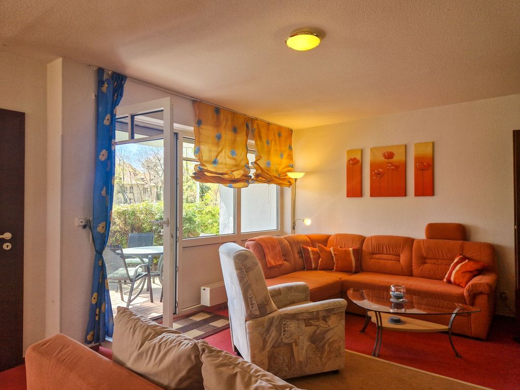 Wohnzimmer mit Sofa und TV, Blick auf die Terrasse