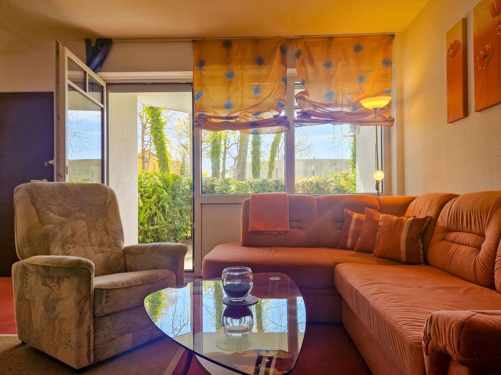 Wohnzimmer mit Sofa und TV, Blick auf die Terrasse