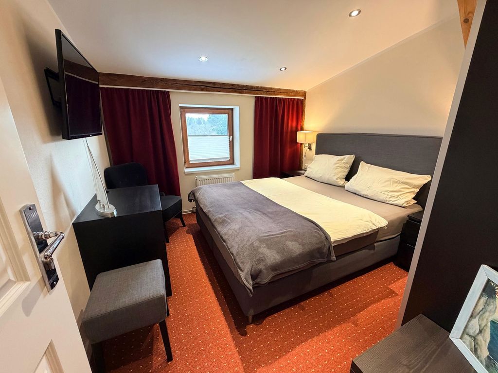 Schlafzimmer mit Doppelbett und TV