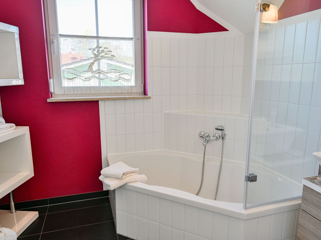 Badezimmer mit Badewanne und integrierter Duschmöglichkeit