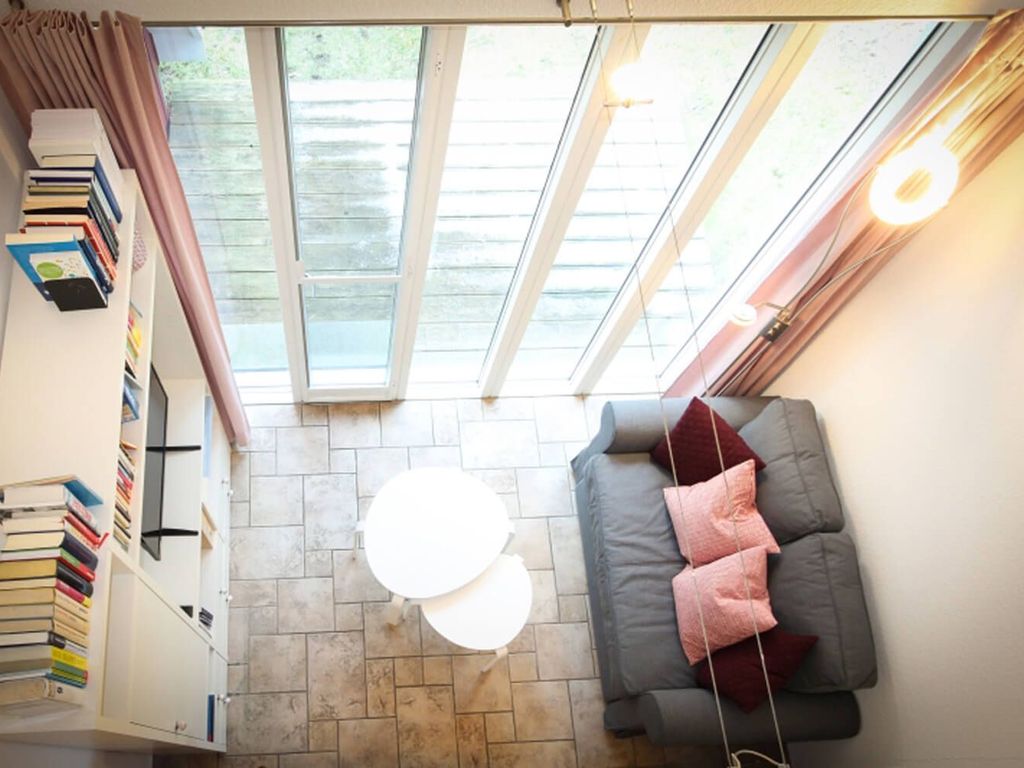 Blick vom OG in den Wohnbereich mit Couch und Flatscreen-TV