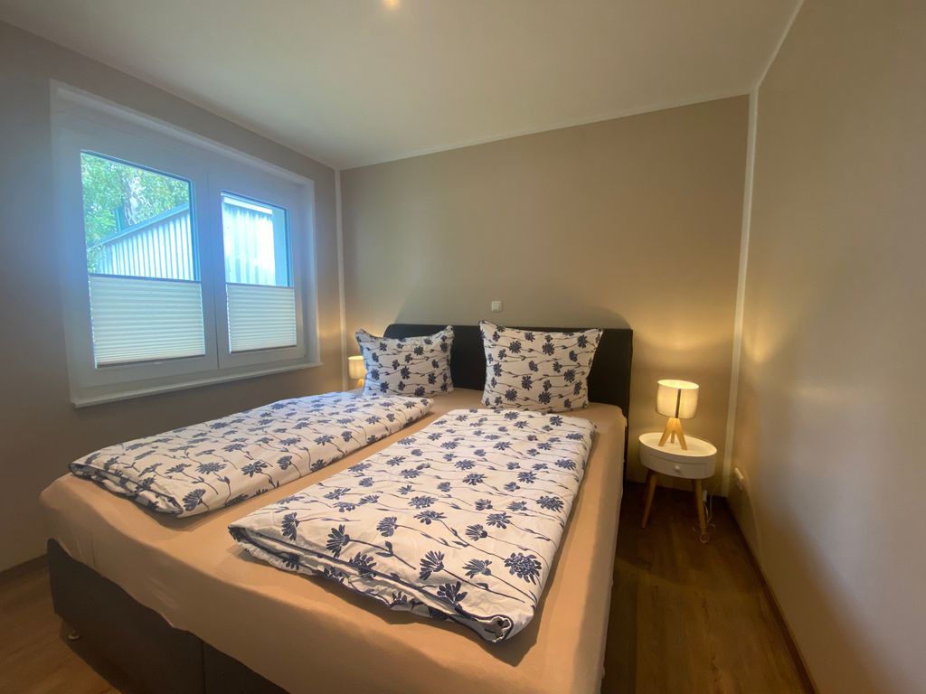 Schlafzimmer mit Fernseher und Außenjalousien
