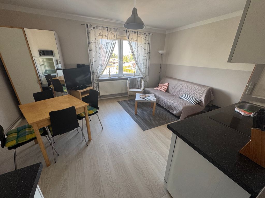 Heller Wohn- und Essbereich der Ferienwohnung Seewind in zentraler Lage von Karlshagen auf der Insel Usedom mit offener Küchenzeile, Essplatz und gemütlicher Sitzecke.