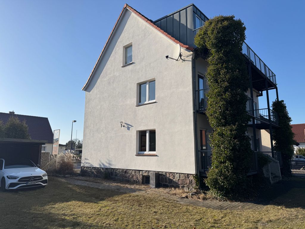 Seiten- und Rückansicht des Ferienhauses Seewind in Karlshagen mit Balkonen und einladendem Haupteingang. Der Ortskern, der feinsandige Ostseestrand und der Küstenwald sind in wenigen Gehminuten erreichbar.