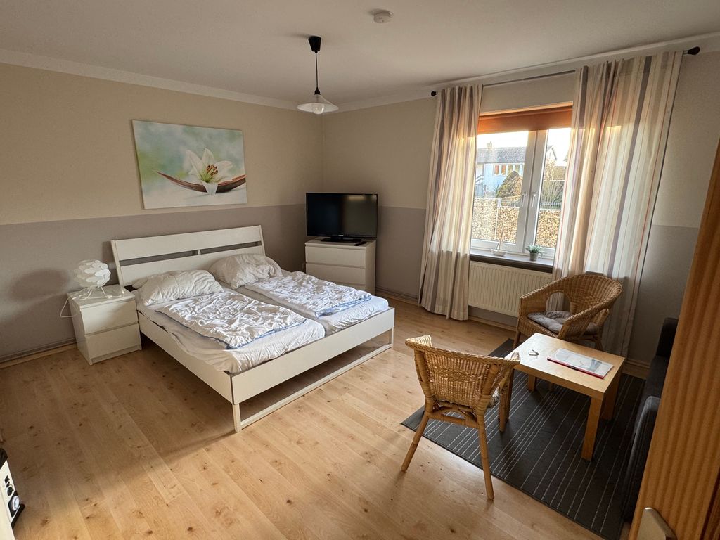 Großzügiger Wohn- und Schlafbereich der Ferienwohnung Seewind in zentraler Lage von Karlshagen auf der Insel Usedom mit Doppelbett, TV und gemütlicher Sitzecke.