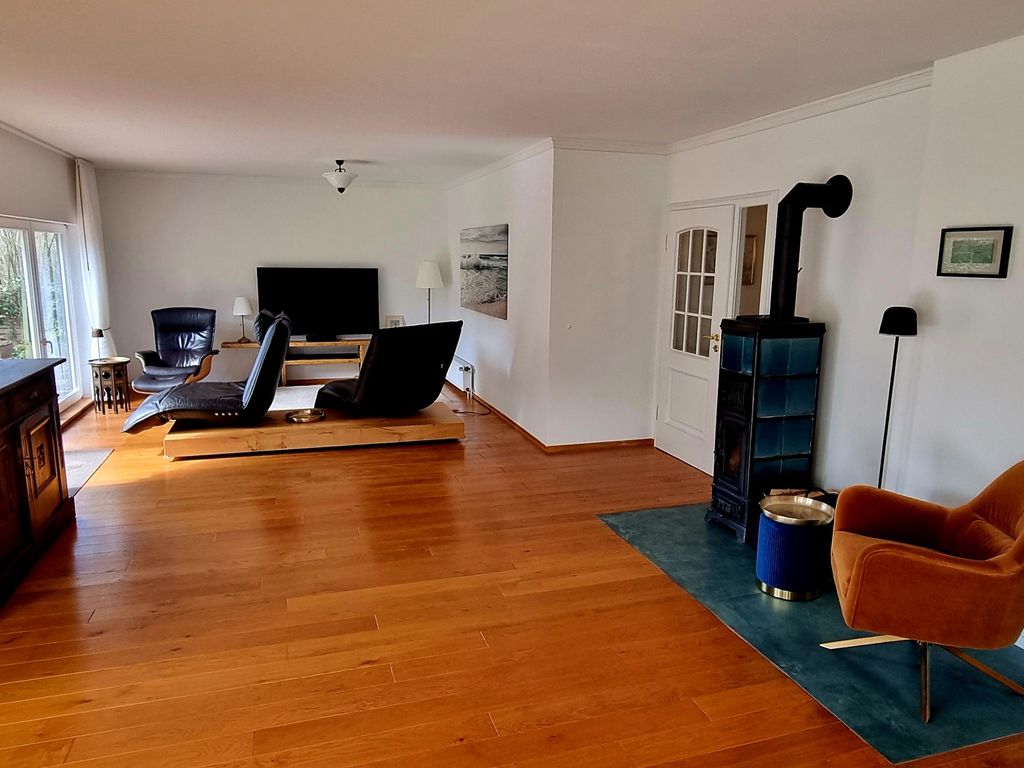 Großzüger Wohnbereich mit Sofa, Kaminbereich und Terassenzugang