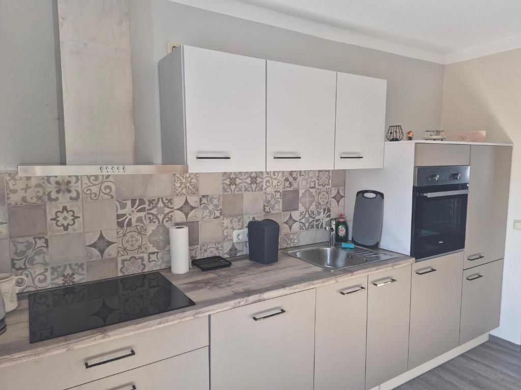 Küchenzeile mit Backofen, Kühlschrank und Küchengeräten