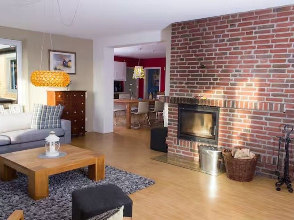 großes Wohnzimmer mit Kamin und viel Licht.
