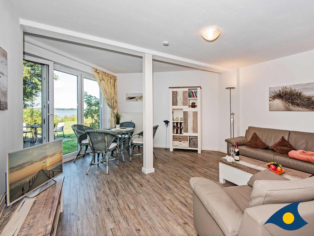 Wohnbereich mit separierter offener Küche und Zugang zur Terrasse