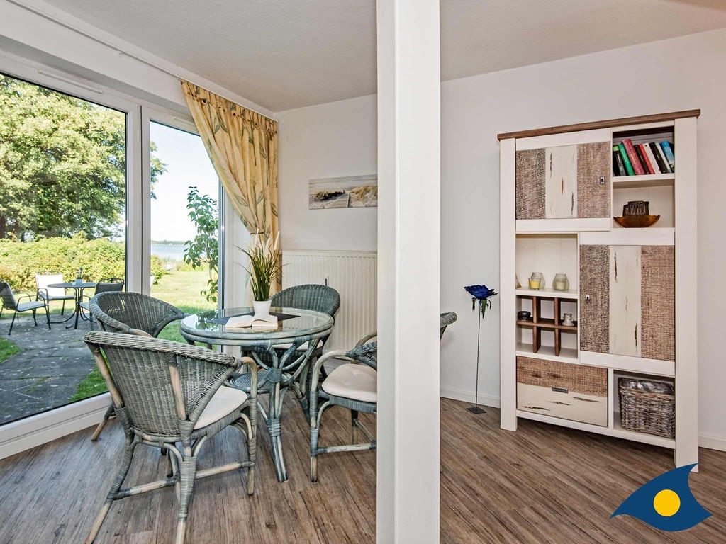 Wohnbereich mit separierter offener Küche und Zugang zur Terrasse