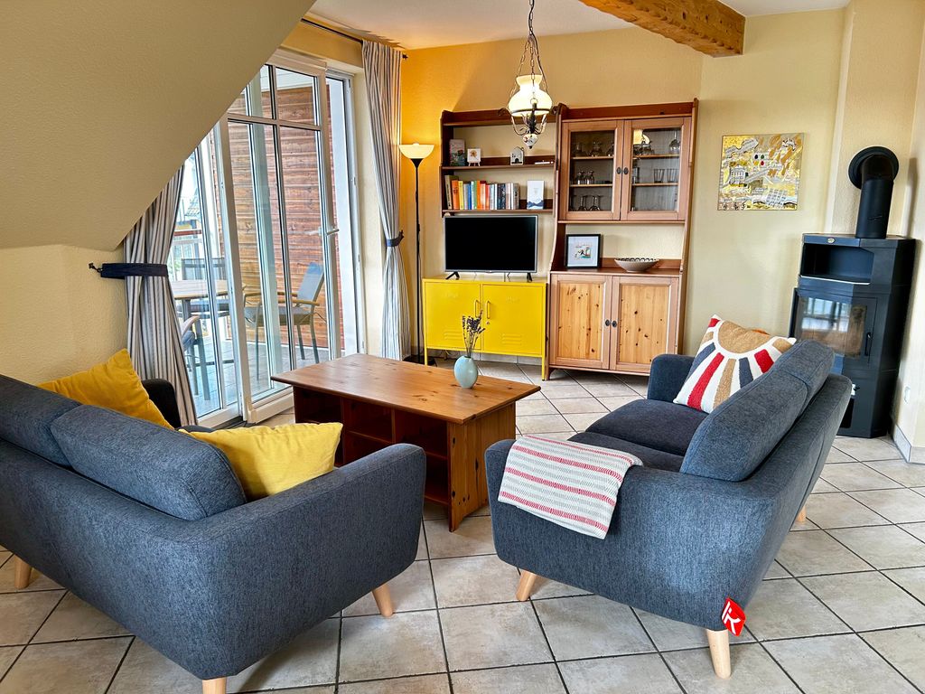 Wohnzimmer mit offener Küche, Essbereich, Kamin und Smart-TV
