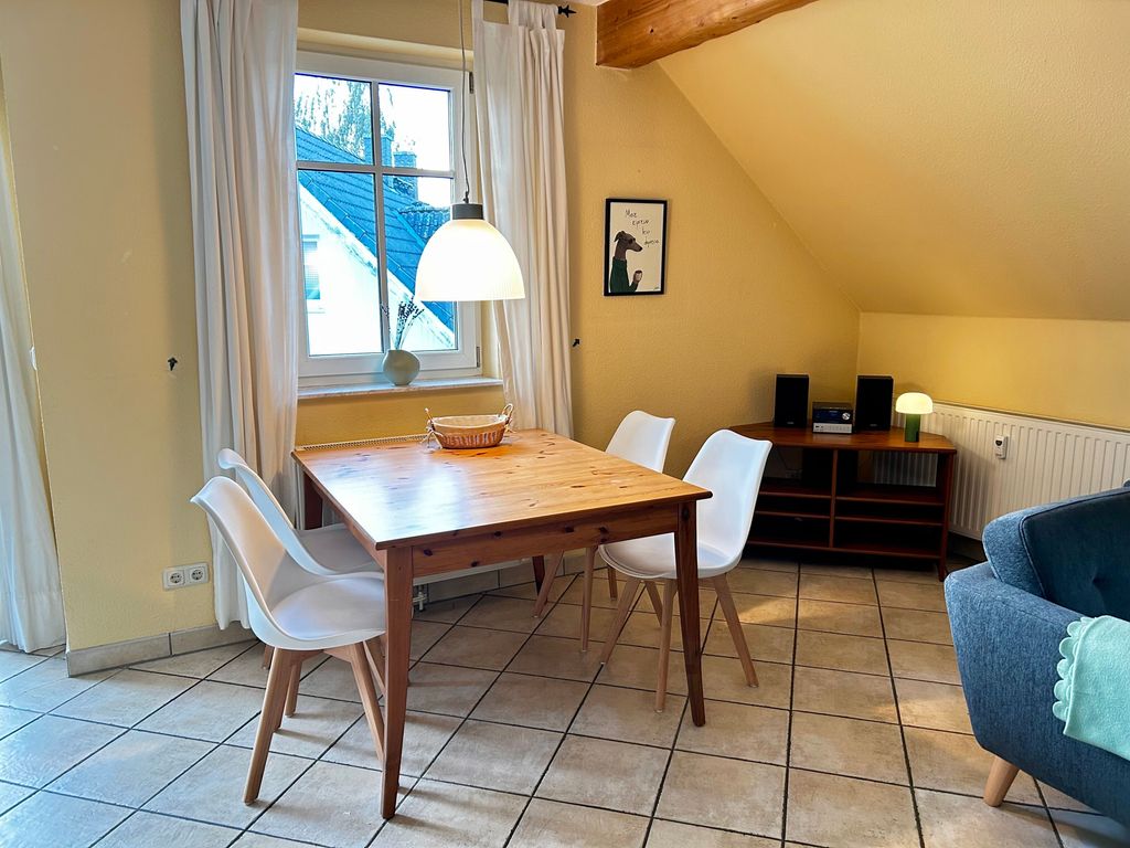 Wohnzimmer mit offener Küche, Essbereich, Kamin und Smart-TV