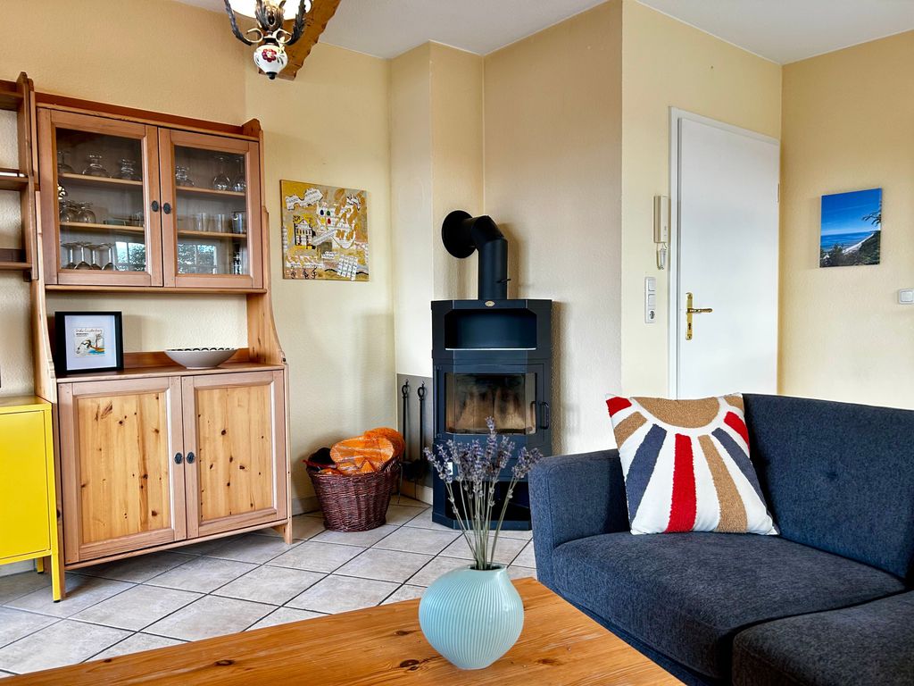 Wohnzimmer mit offener Küche, Essbereich, Kamin und Smart-TV