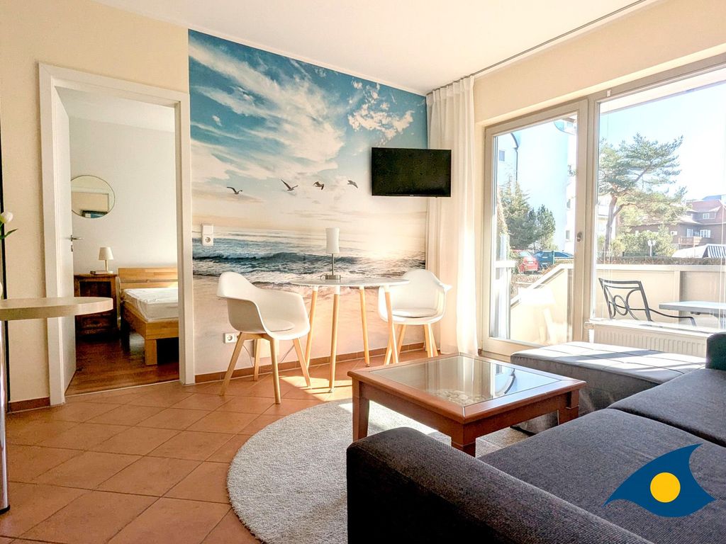 offener Wohnbereich mit Küchenzeile und Zugang zum Balkon