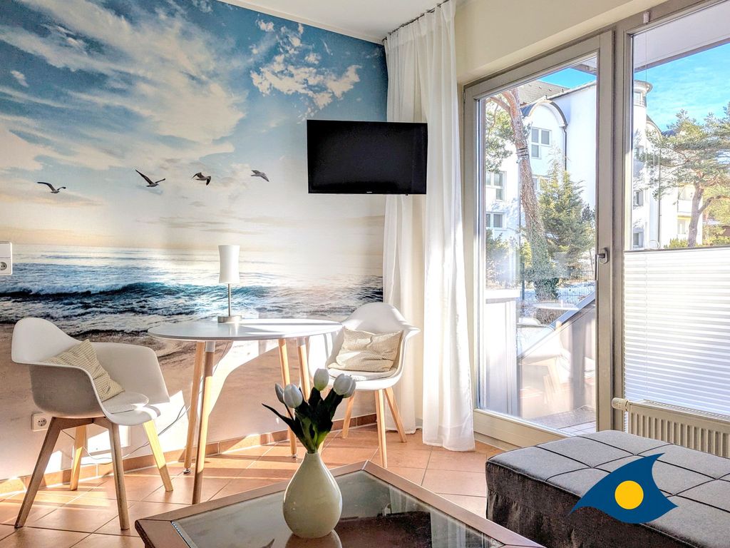 offener Wohnbereich mit Küchenzeile und Zugang zum Balkon