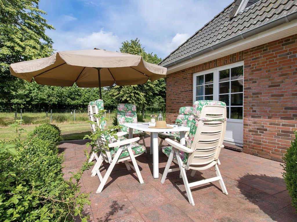 Terrasse mit Sitzmöbeln und Sonnenschirm