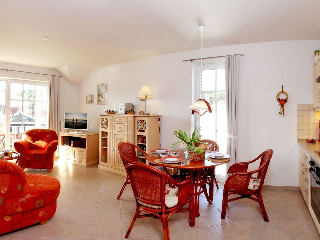 Wohnbereich mit offener Küche und Zugang zum Balkon