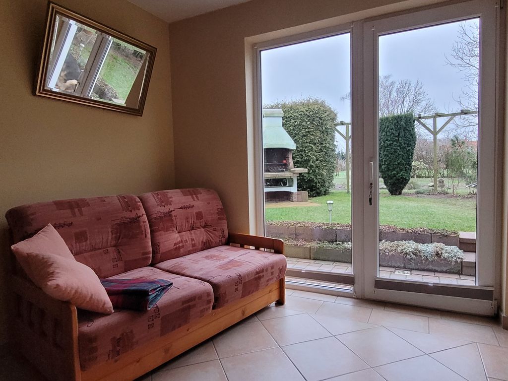 Wohnbereich mit Couch und Terrassentür zum Garten
