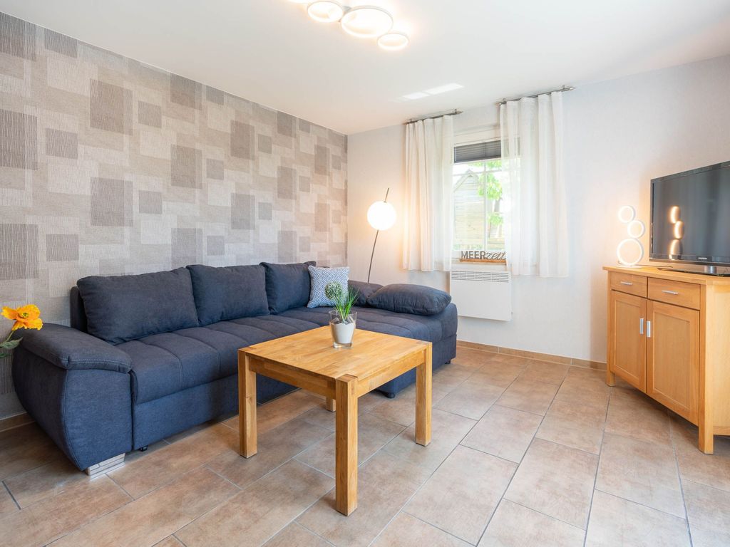 Das Ferienhaus Mimi im Ostseebad Karlshagen auf der Insel Usedom zeigt den gemütlichen Wohnbereich mit großen Sofa und einem Fernseher für schöne Fernseheabende.
