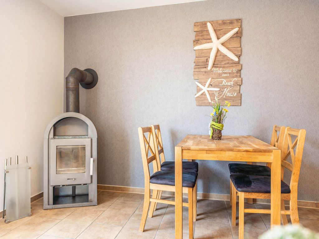 Das Ferienhaus Mimi im Ostseebad Karlshagen auf der Insel Usedom zeigt den Essbereich mit Esstisch und Kaminofen.