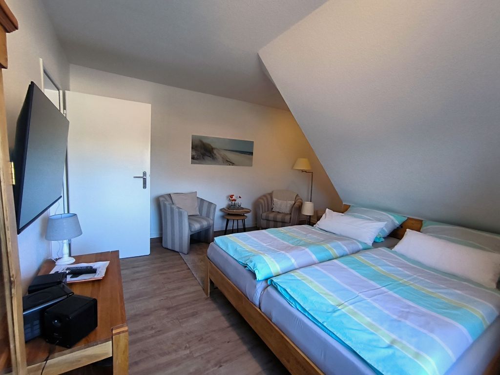 Schlafzimmer mit Doppelbett, TV und Sitzecke