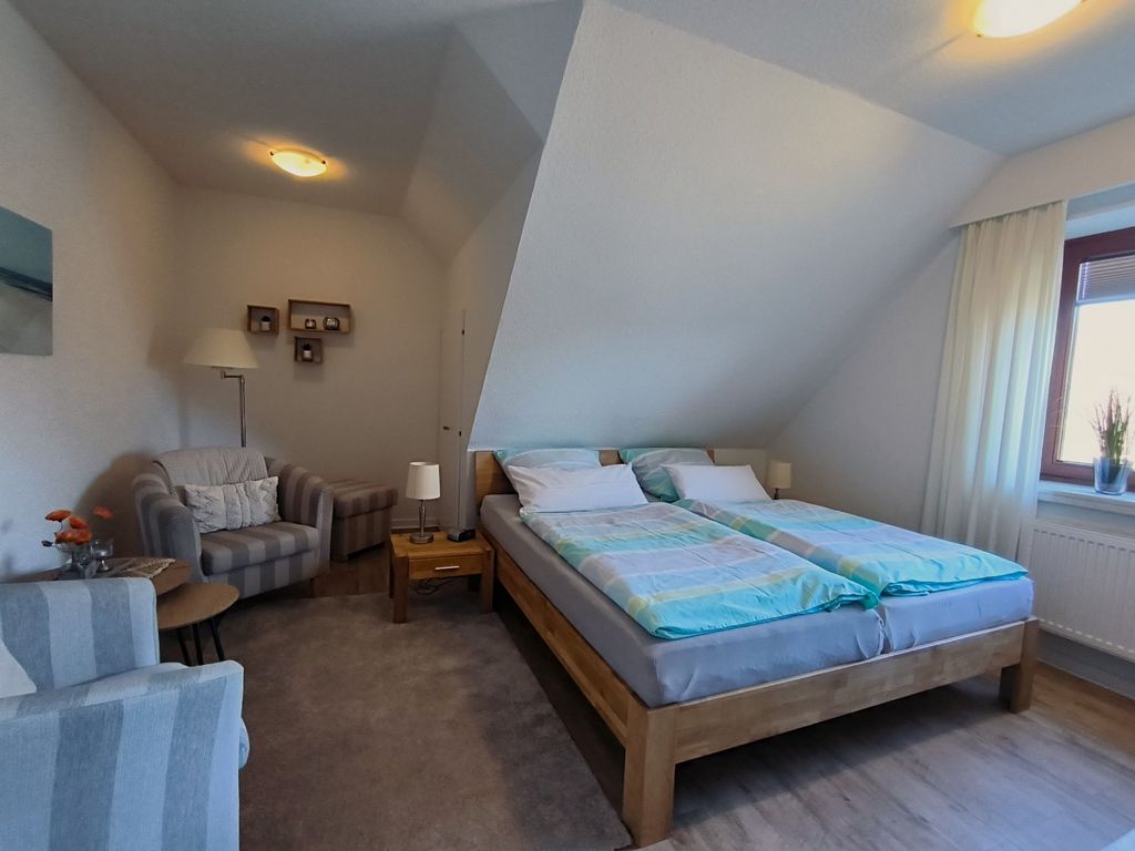 Schlafzimmer mit Doppelbett, TV und Sitzecke